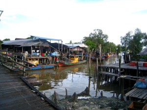 A wonderful palette.Vividly colored boats contrasts well to the dark woods of the bridges atop azure blue sky.